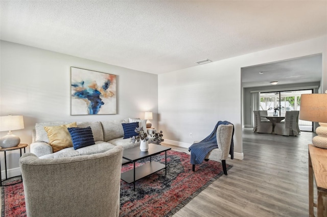 living room featuring hardwood / wood-style flooring and a textured ceiling