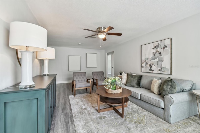 living room with hardwood / wood-style flooring, ceiling fan, and a textured ceiling