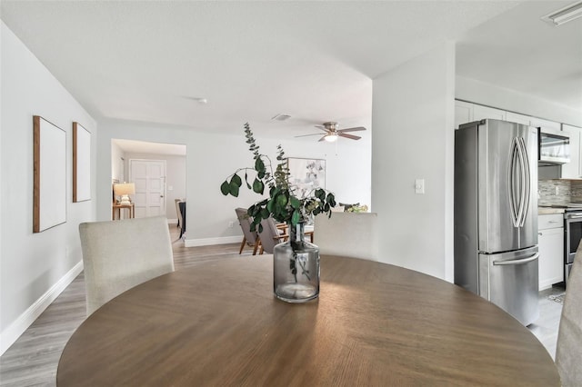 dining room with hardwood / wood-style flooring and ceiling fan