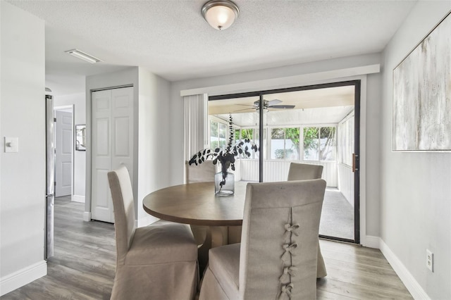 dining space with ceiling fan, hardwood / wood-style flooring, and a textured ceiling