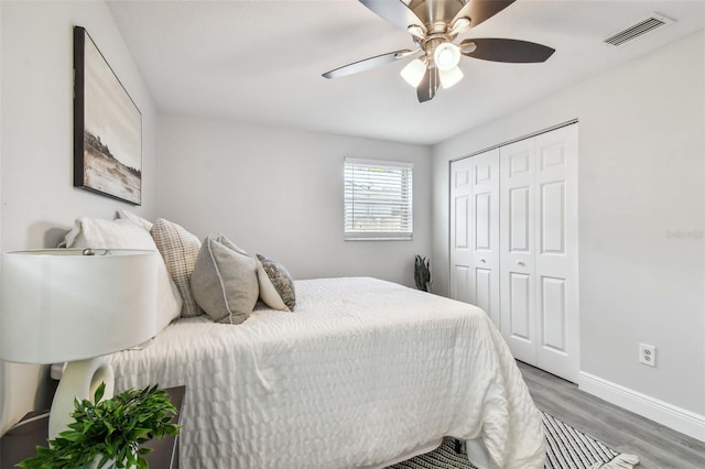 bedroom with ceiling fan, wood-type flooring, and a closet