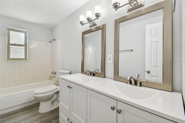 full bathroom featuring hardwood / wood-style flooring, vanity, toilet, and tiled shower / bath combo