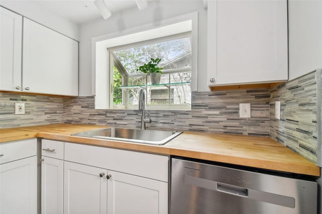 kitchen featuring sink, stainless steel dishwasher, white cabinets, and butcher block countertops