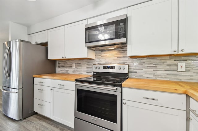 kitchen featuring wood counters, backsplash, stainless steel appliances, and white cabinets