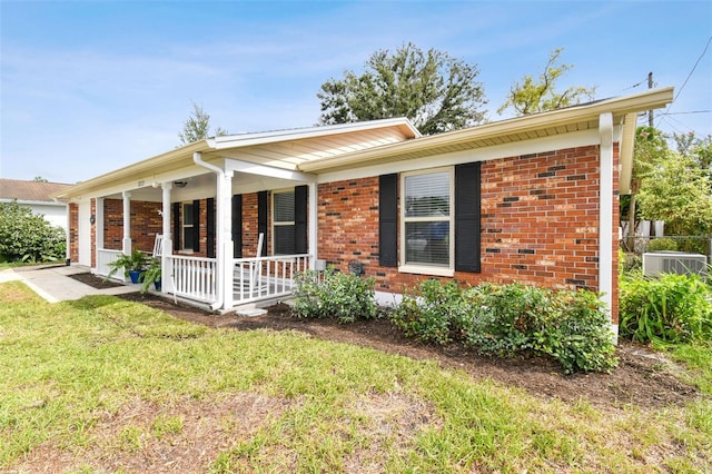 view of front of property featuring a porch, central AC unit, and a front lawn