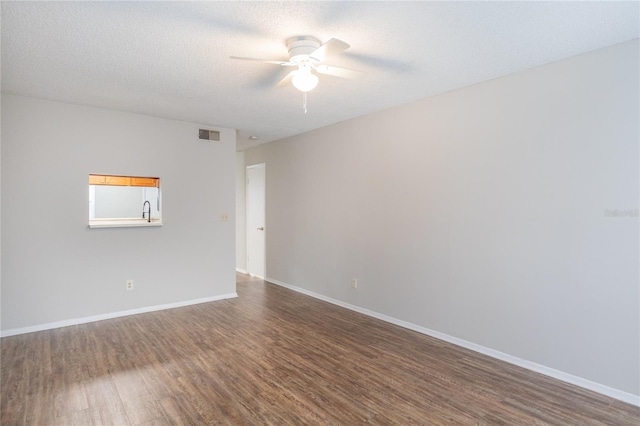 unfurnished room with ceiling fan, dark wood-type flooring, sink, and a textured ceiling