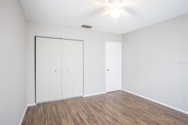 unfurnished bedroom with ceiling fan, hardwood / wood-style flooring, a closet, and a textured ceiling