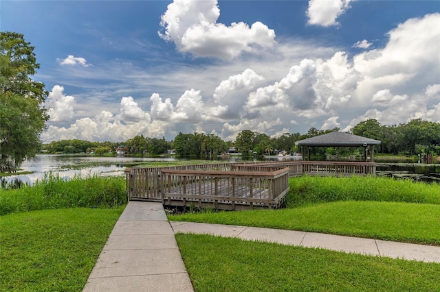 view of home's community with a gazebo, a water view, and a lawn