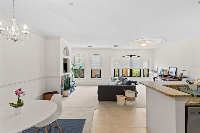 living room with light carpet, light tile patterned floors, ornamental molding, and ceiling fan with notable chandelier