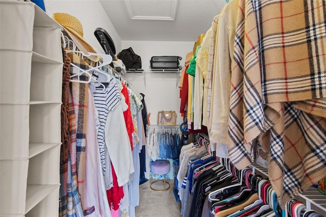 spacious closet featuring carpet floors and attic access