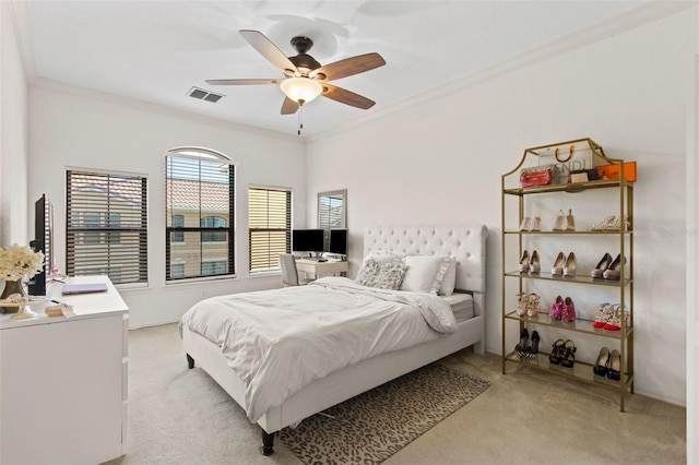 bedroom featuring visible vents, light colored carpet, a ceiling fan, and ornamental molding