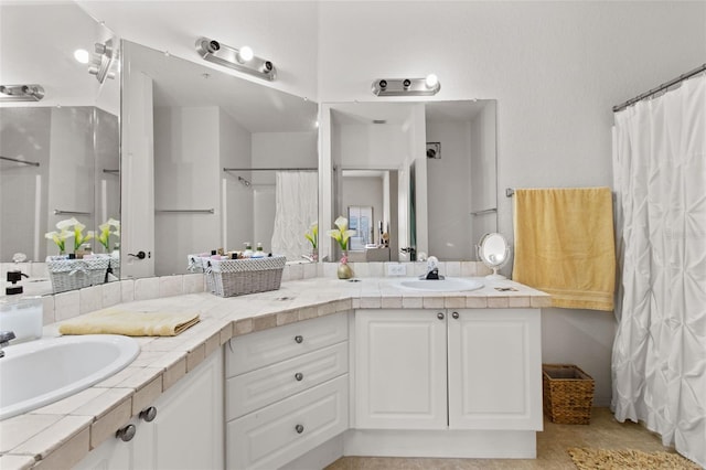 bathroom featuring a shower with curtain, a sink, and double vanity