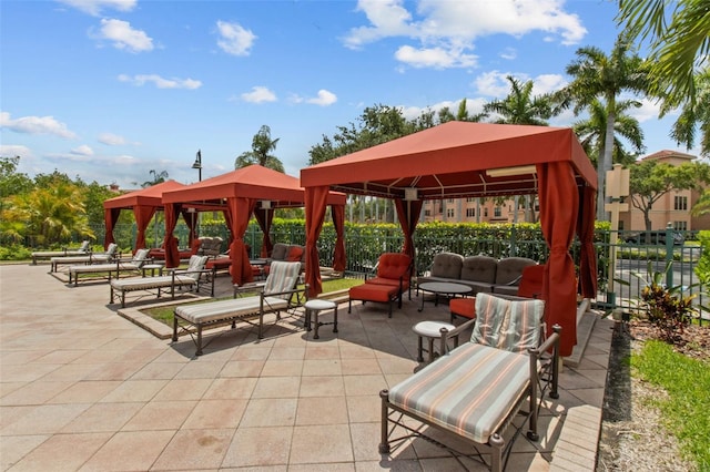 view of community featuring fence, a gazebo, and a patio