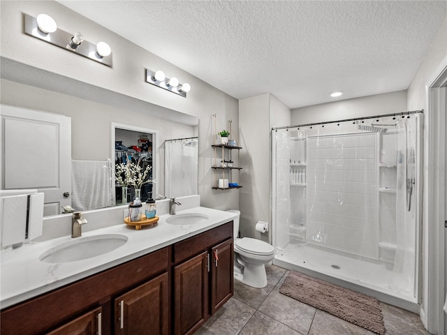 bathroom with vanity, curtained shower, a textured ceiling, and toilet