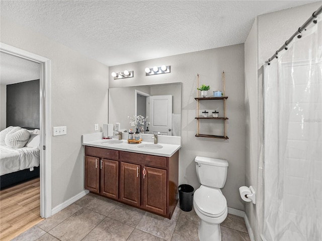 bathroom featuring tile patterned flooring, vanity, a textured ceiling, curtained shower, and toilet