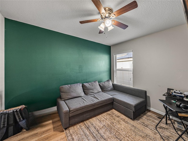 living room with wood-type flooring, a textured ceiling, and ceiling fan