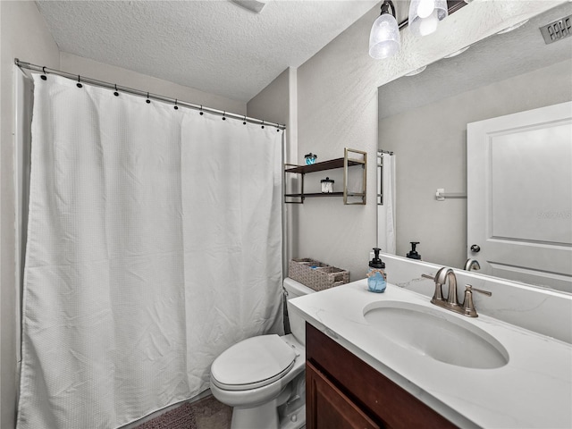 bathroom with vanity, toilet, and a textured ceiling