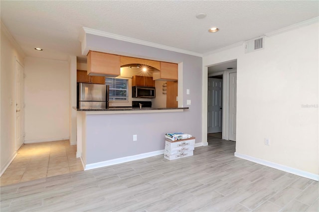 kitchen with crown molding, appliances with stainless steel finishes, kitchen peninsula, and a textured ceiling