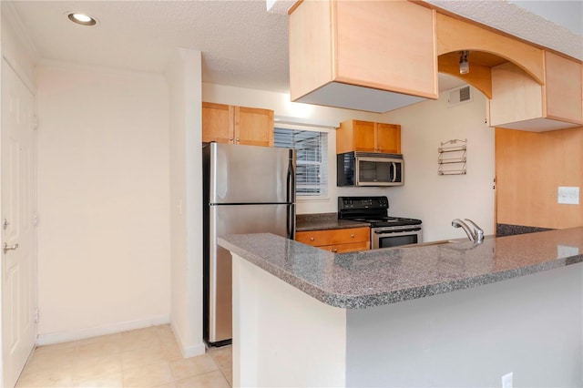 kitchen with a breakfast bar, sink, a textured ceiling, kitchen peninsula, and stainless steel appliances