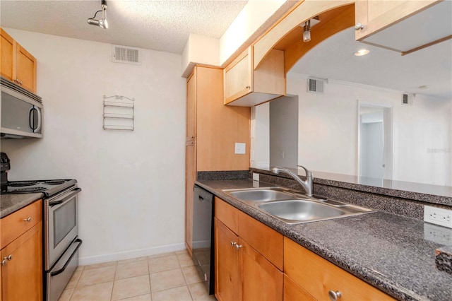 kitchen featuring light tile patterned flooring, stainless steel appliances, sink, and a textured ceiling