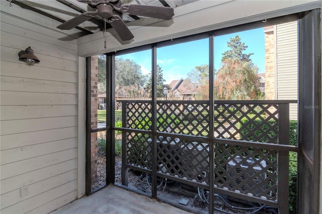 unfurnished sunroom with ceiling fan