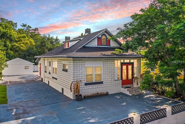 view of front of house featuring a garage, an outbuilding, and a patio area