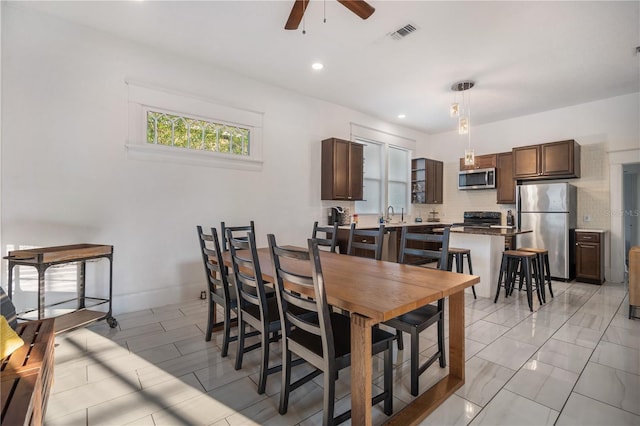 dining space featuring sink and ceiling fan