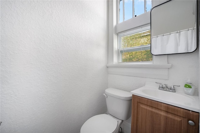 bathroom with vanity, plenty of natural light, and toilet