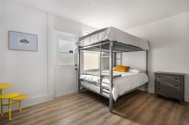 bedroom with dark hardwood / wood-style flooring and a textured ceiling