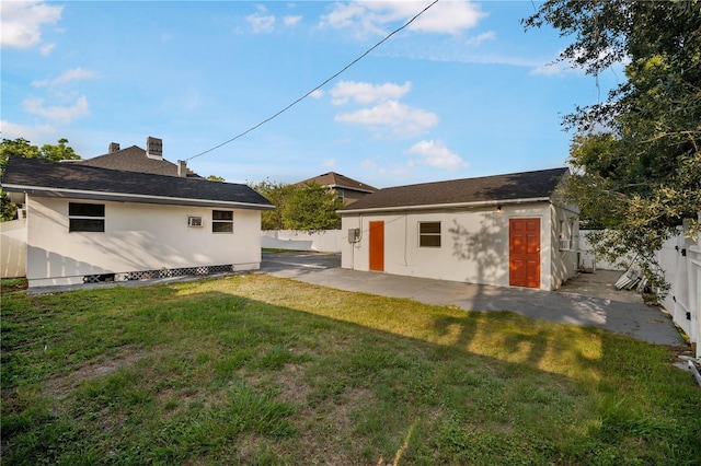 rear view of house with a yard, a patio area, and an outdoor structure