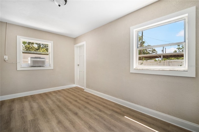 unfurnished room with cooling unit and wood-type flooring