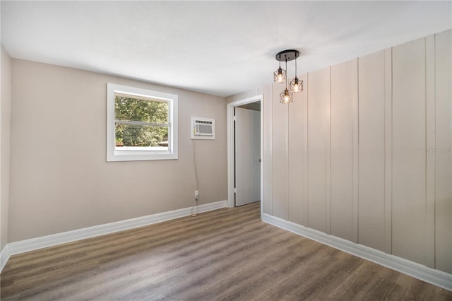 spare room featuring a wall mounted AC and hardwood / wood-style floors