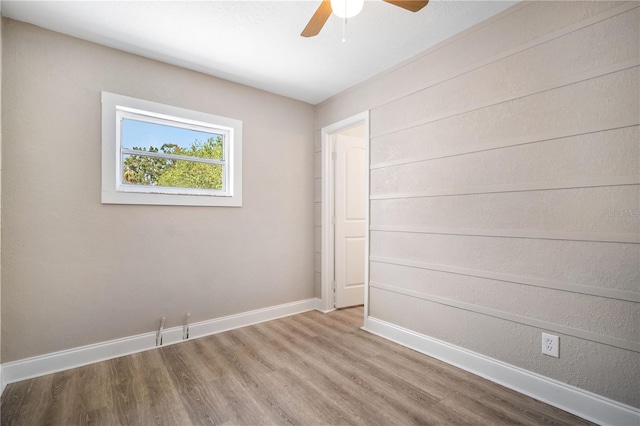 empty room with hardwood / wood-style floors and ceiling fan