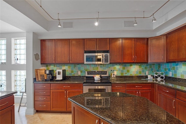 kitchen featuring dark stone countertops, tasteful backsplash, and appliances with stainless steel finishes