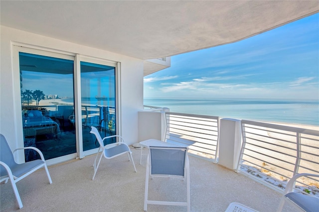 balcony featuring a water view and a view of the beach