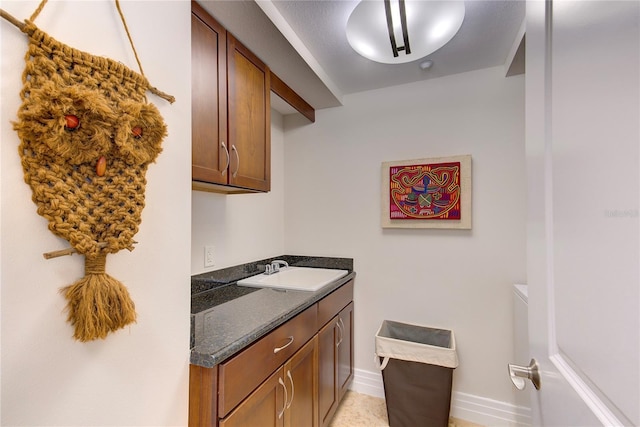 kitchen featuring dark stone counters and sink