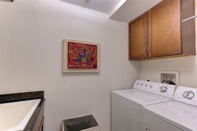 clothes washing area featuring cabinets, washing machine and dryer, and sink