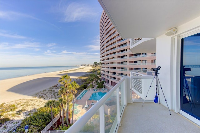 balcony featuring a view of the beach and a water view