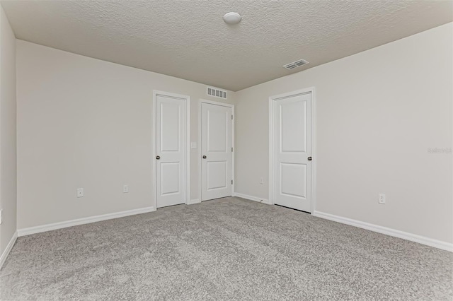 carpeted spare room with a textured ceiling