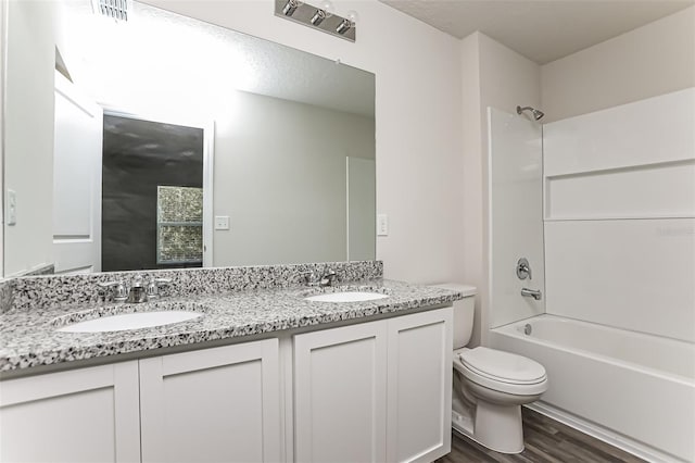 full bathroom with shower / tub combination, wood-type flooring, toilet, and vanity