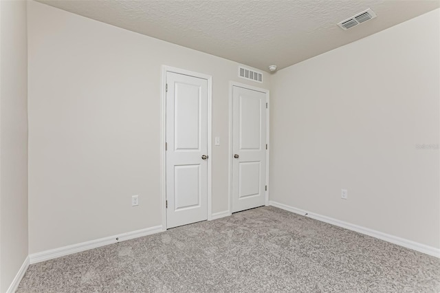 unfurnished bedroom with light carpet and a textured ceiling