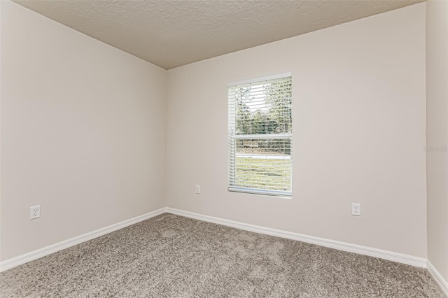 carpeted empty room with a textured ceiling