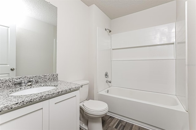 full bathroom with hardwood / wood-style floors, vanity, toilet, bathing tub / shower combination, and a textured ceiling