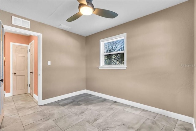 empty room with ceiling fan and light tile patterned floors