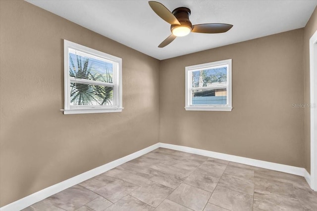 spare room with ceiling fan and a wealth of natural light