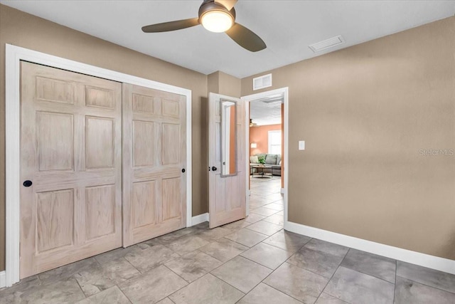 unfurnished bedroom featuring light tile patterned floors, ceiling fan, and a closet