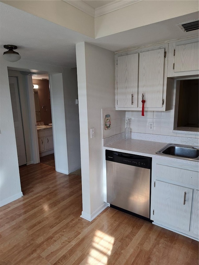 kitchen featuring sink, tasteful backsplash, crown molding, light wood-type flooring, and dishwasher