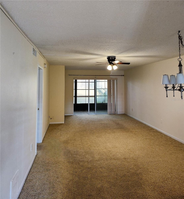 carpeted empty room featuring ceiling fan and a textured ceiling