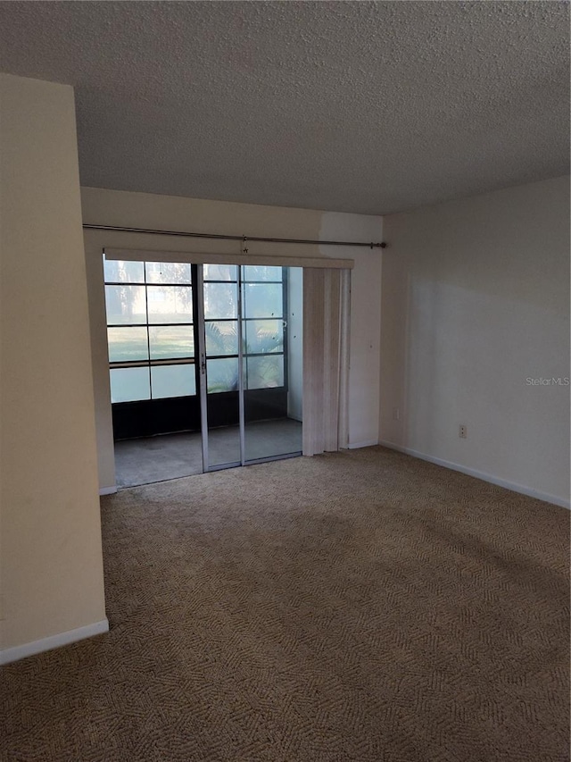 empty room featuring carpet flooring and a textured ceiling