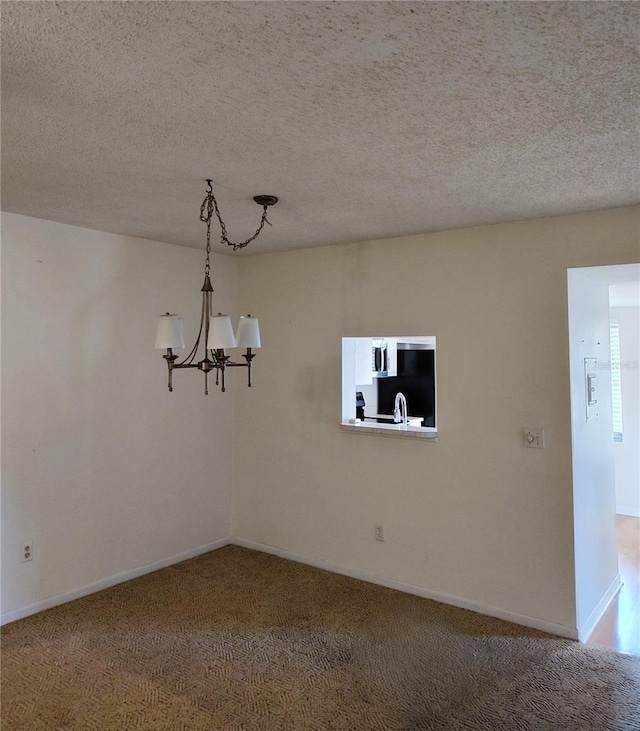 carpeted empty room featuring an inviting chandelier and a textured ceiling